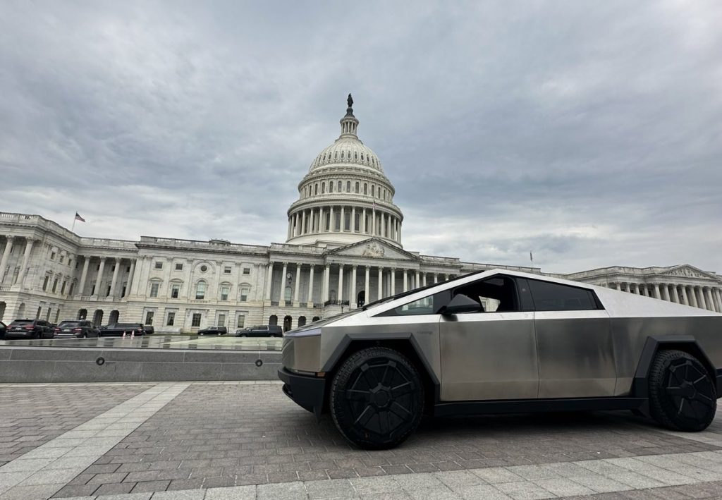 A Tesla Cybertruck with a stainless steel exterior and angular design is parked in front of the U.S. Capitol under a cloudy sky, creating a contrast between futuristic technology and historic architecture." Let me know if you'd like any refinements