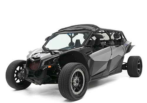 This image shows a black off-road side-by-side vehicle with an aggressive design, large rugged tires, and a roll cage built for high-performance adventure riding.