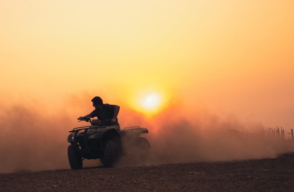 Quad bike rider enjoying the open terrain at sunset—ready for street-legal registration so the adventure can continue on and off the road.