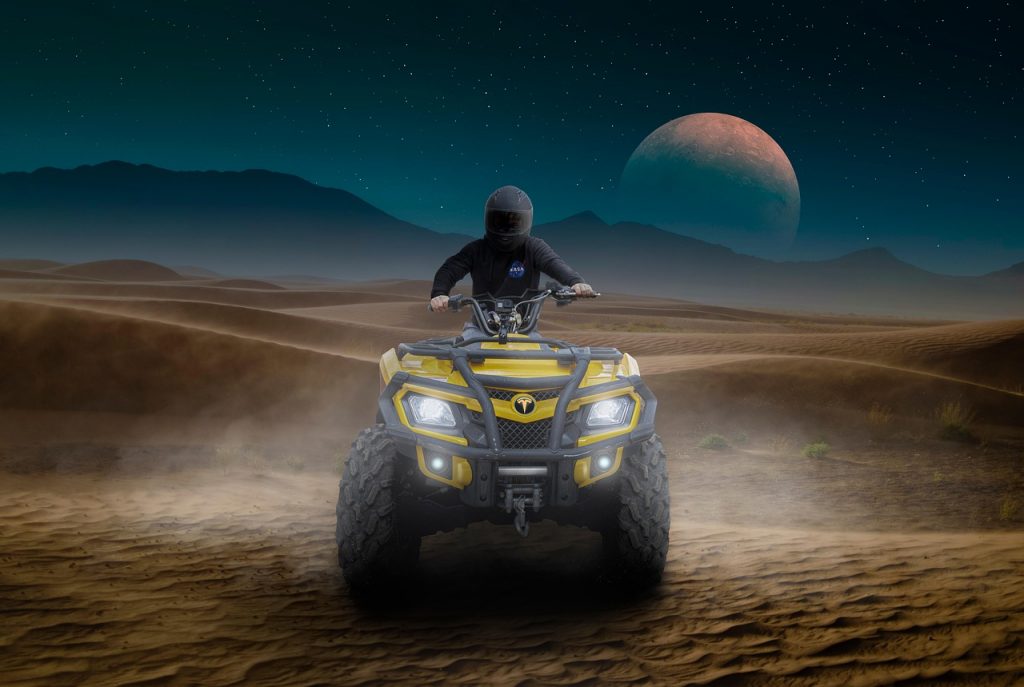 A rider powers through the desert on an ATV beneath a surreal night sky—showcasing the thrill of off-road freedom made even better with street-legal dirt bike registration.