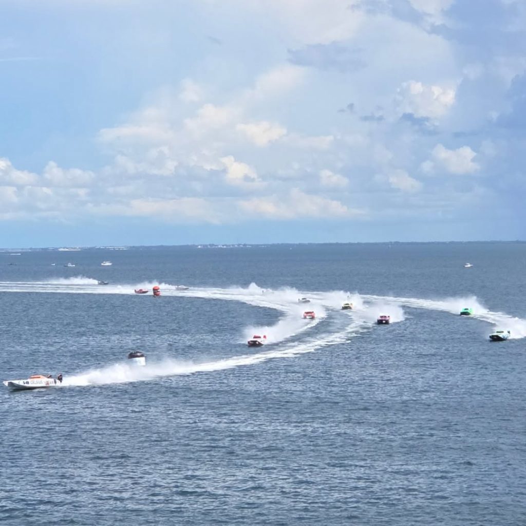 A fleet of high-speed powerboats races across open water, leaving sweeping trails of spray behind them—showcasing the excitement of boating and the value of Montana boat registration.