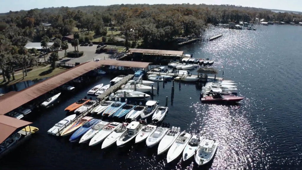 Aerial view of a marina packed with numerous speedboats and power boats docked on a sunny day