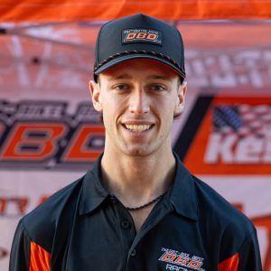 Headshot of Dirt Legal DBDRacing WMR KTM team rider Jace Kessler smiling in a black and orange team polo and cap.